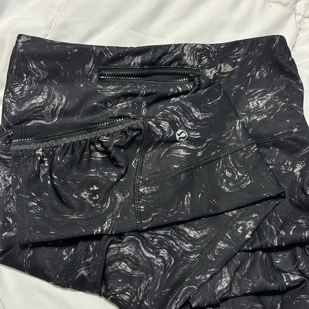 Lululemon black with swirls leggings. Zipper pocket. Zipper ankles. size 4